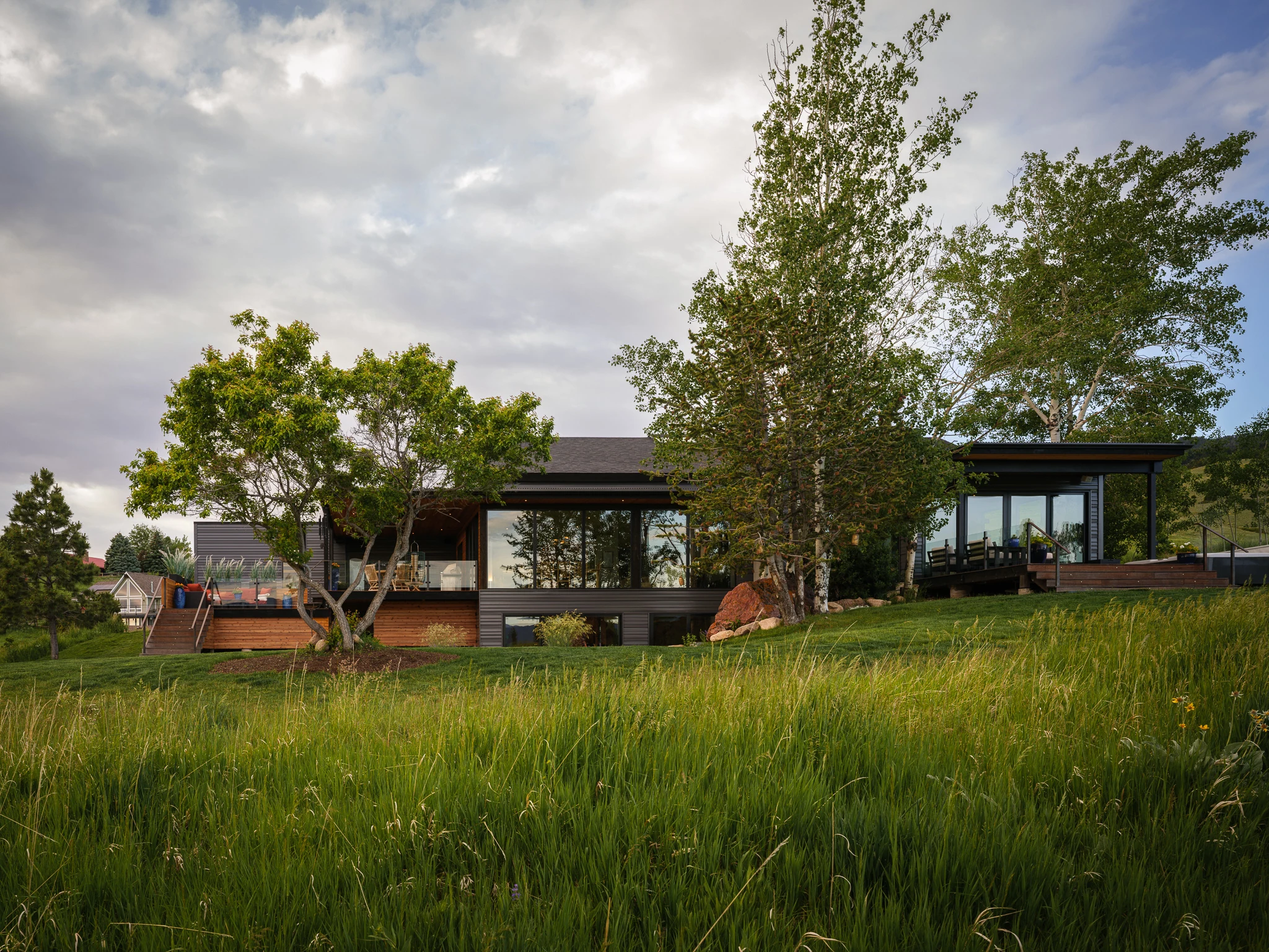 Exterior view of the home at dusk across the open meadow — architectural photography Bozeman Montana, Bozeman Overlook